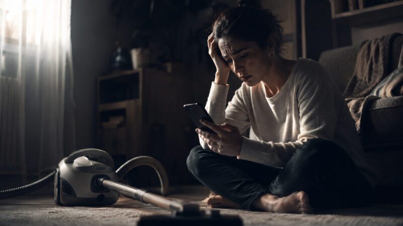 パナソニックMC-PJ23Aの口コミや評判をスマホで調べて後悔や不安を感じる人物と、一般的なデザインのキャニスター掃除機を描いたシリアスなイメージ画像