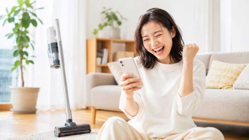 レイコップ PRO2(RS3-300JP)の口コミや評判をスマホで確認して満面の笑顔を見せる女性